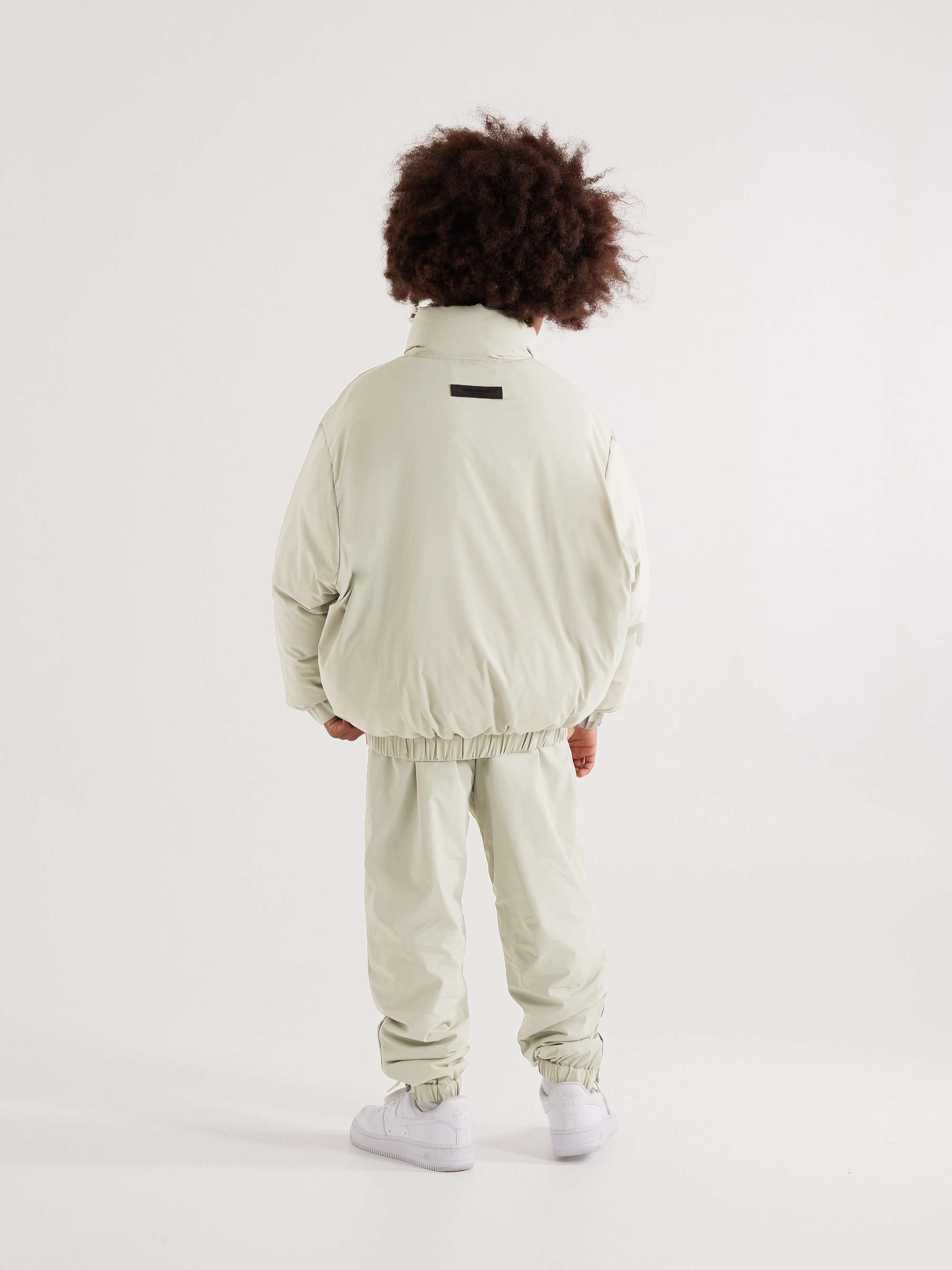 FEAR OF GOD ESSENTIALS KIDS بنطال رياضي من القماش العازل المطاط بقصة تضيق تدريجياً مزين برقعة شعار العلامة