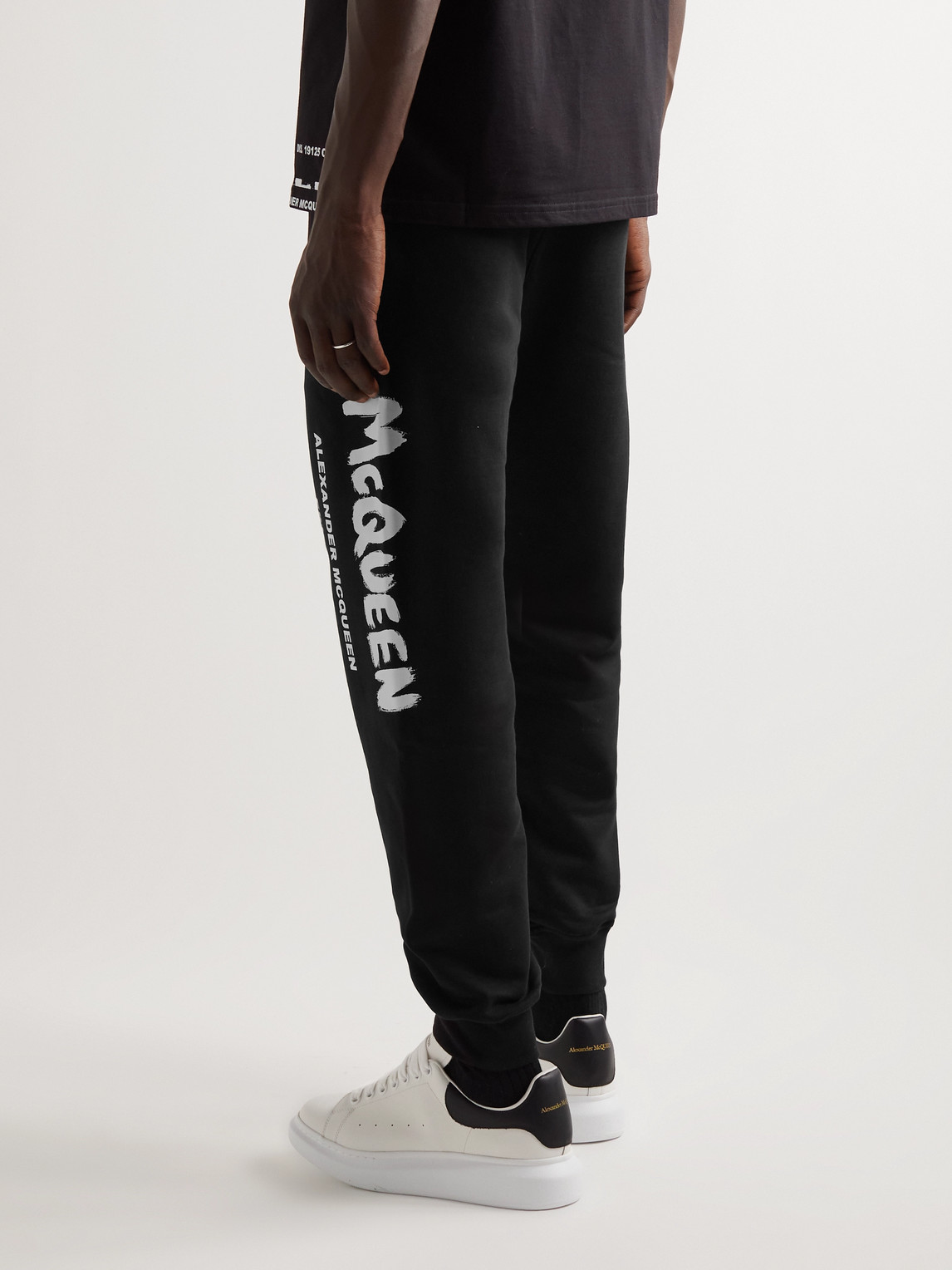 Shop Alexander Mcqueen Tapered Logo-print Loopback Cotton-jersey Sweatpants In Black