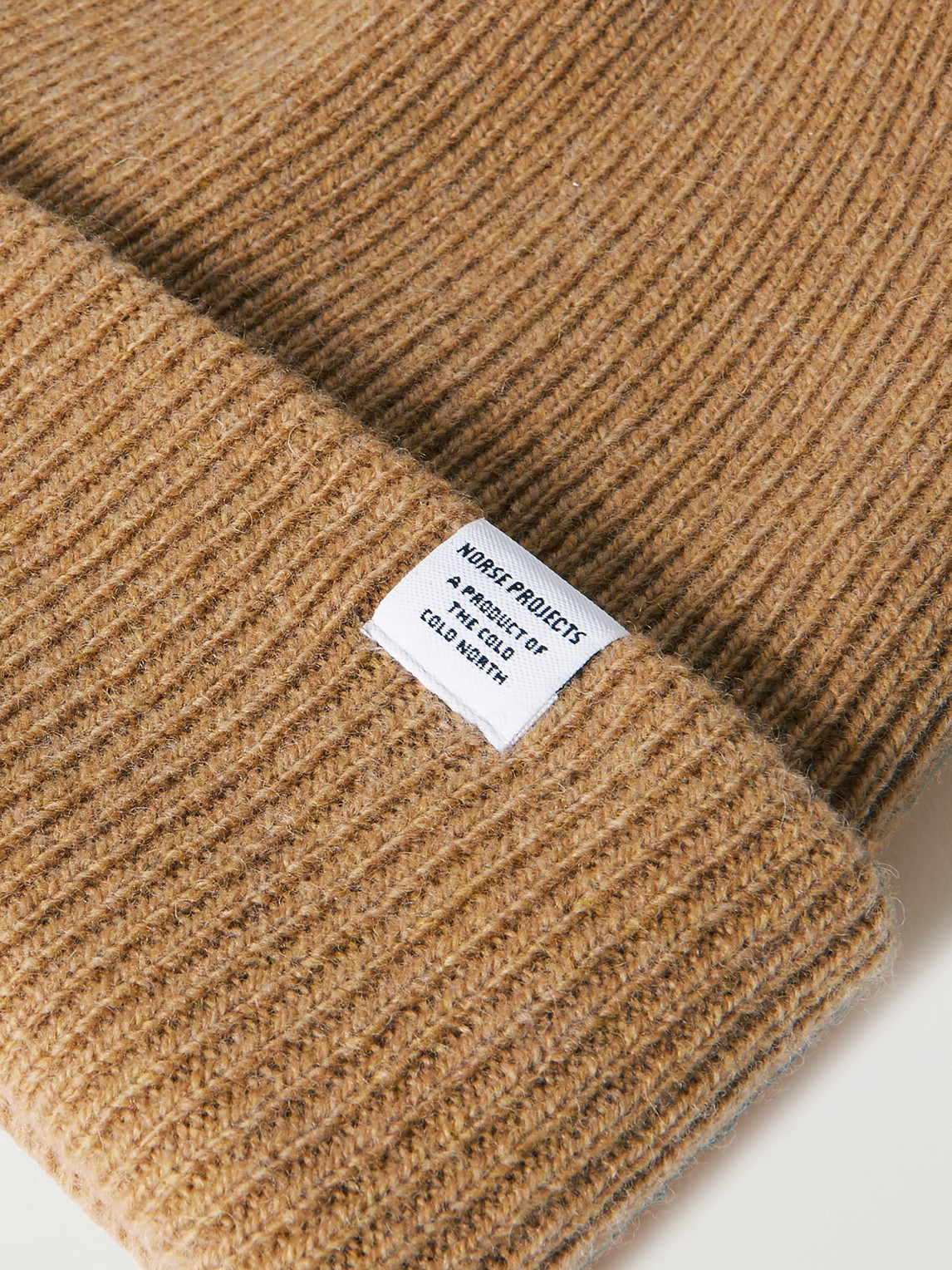 Shop Norse Projects Logo-appliquéd Ribbed Merino Wool Beanie In Brown