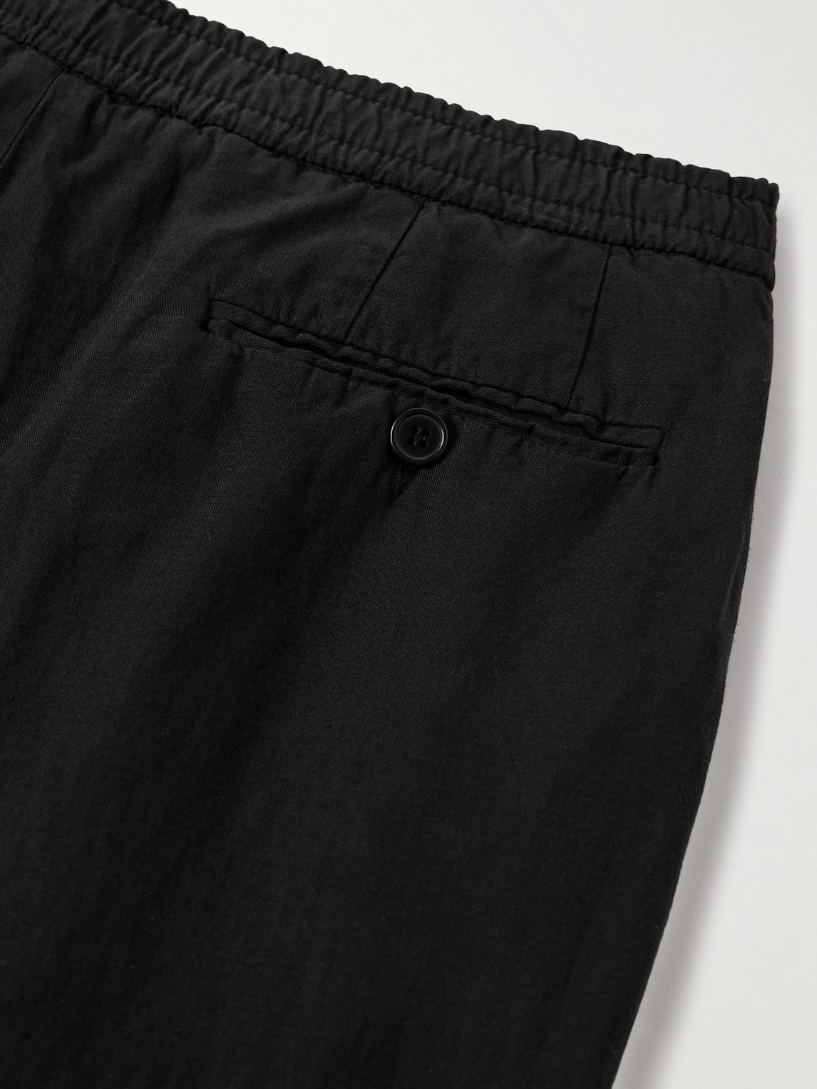 Officine Generale Drew Tapered Pleated Garment-dyed Lyocell-blend Trousers In Black