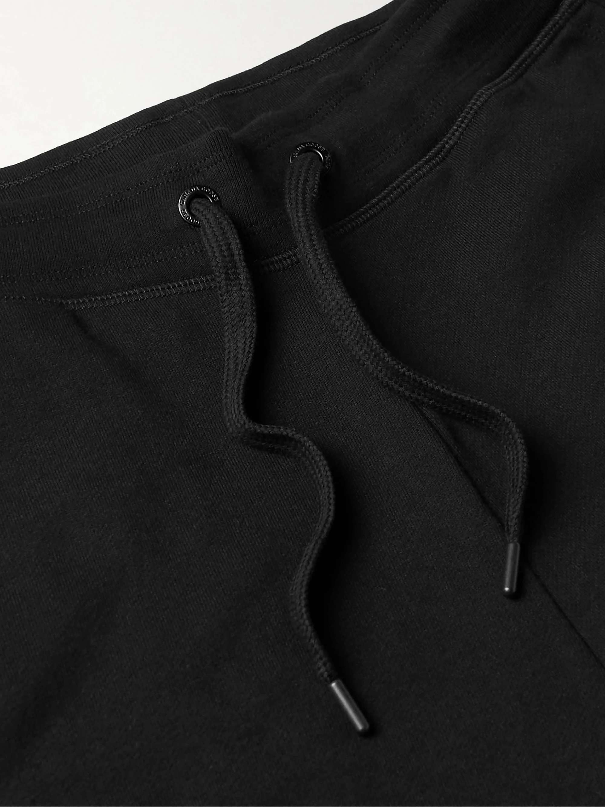 CANADA GOOSE بنطال Huron الرياضي من قطن جيرسي مزين بشعار العلامة بتطريز نافر بقصّة تضيق تدريجياً